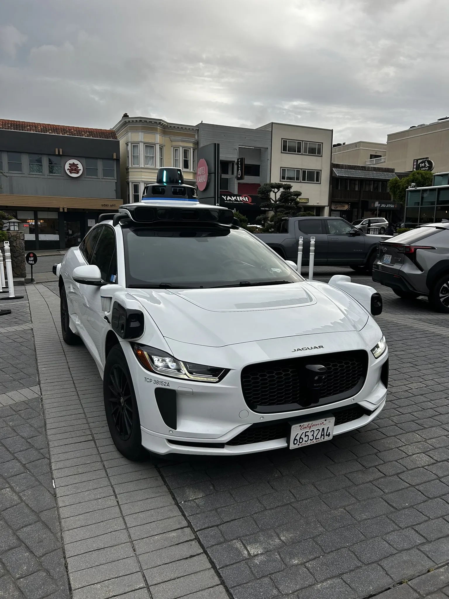 The Waymo Jaguar I-PACE from the front, sensor dome and Jaguar badge visible
