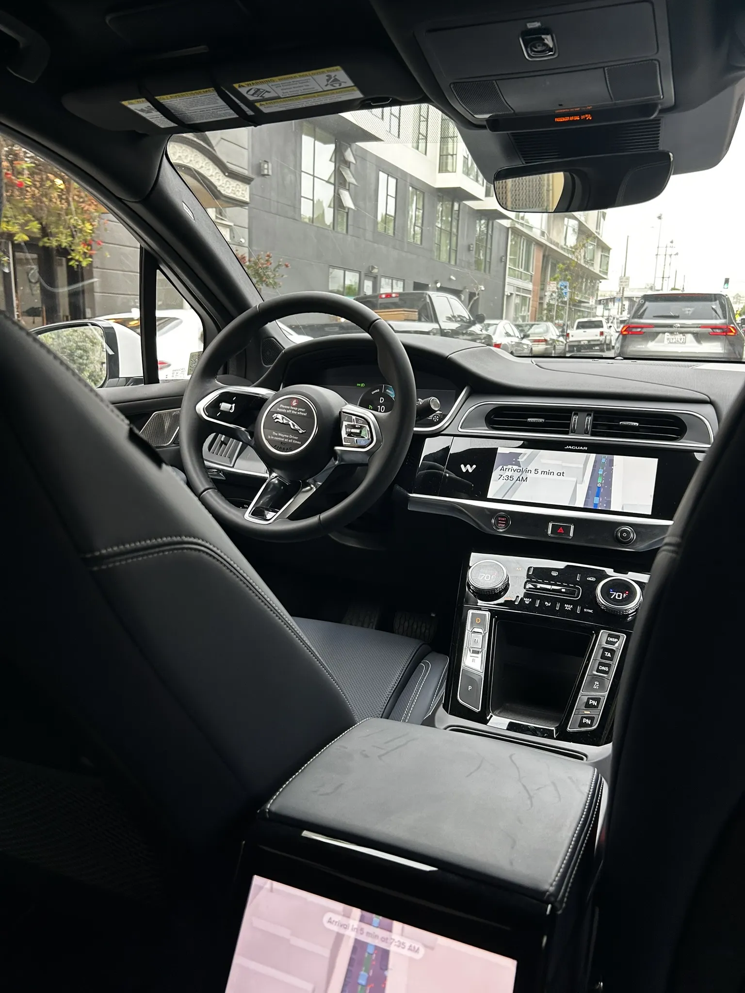 Inside the Waymo, no driver, steering wheel untouched, navigation showing arrival time